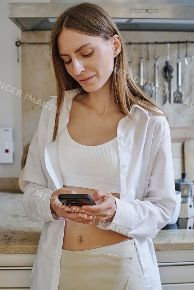 A white woman texting and reading on her smartphone