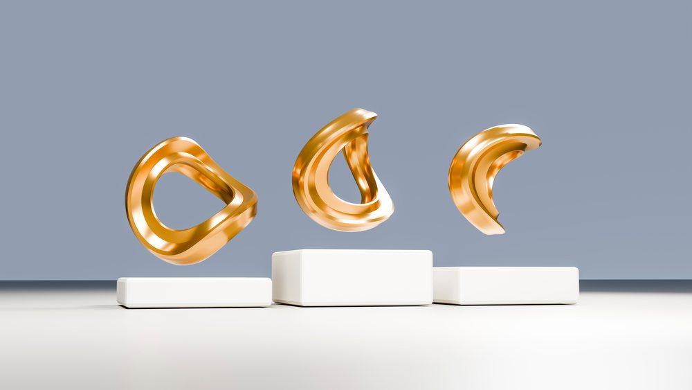 Three golden abstract sculptures float elegantly above white rectangular pedestals in a minimalist studio with a smooth gray wall.