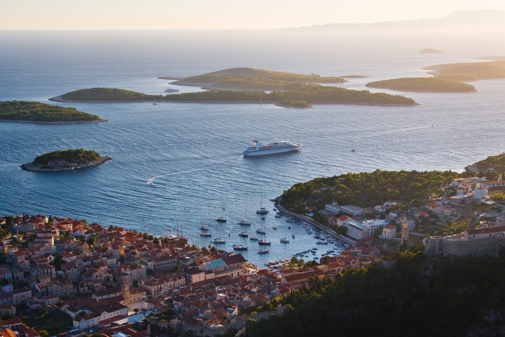 Hvar harbor with boats and cruise ship among islands, Dusk, Croatia.