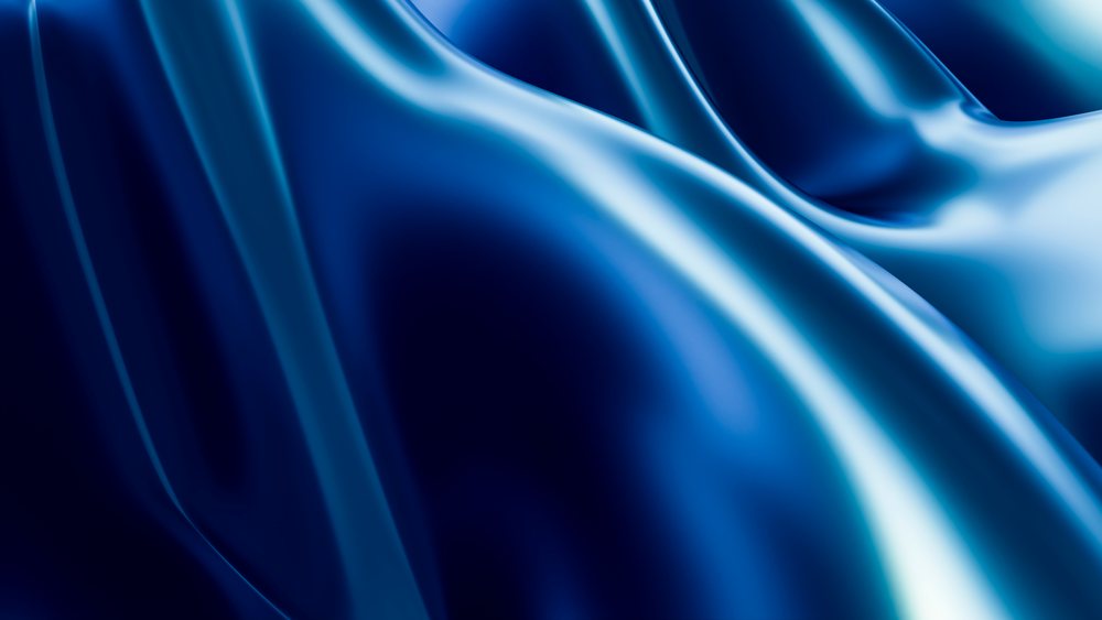 Blue shiny silk fabric displaying smooth folds and reflective surfaces.