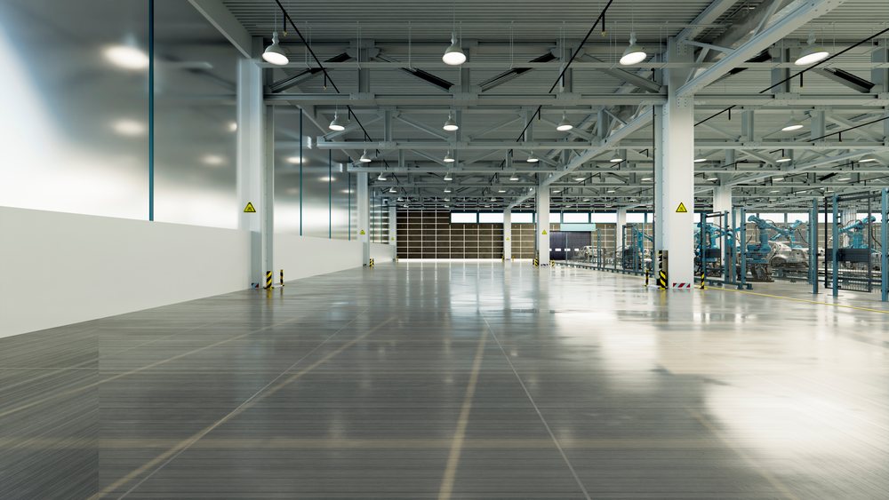 Robotic arms assembling car frames on an automobile production line inside a spacious industrial factory workspace, manufacturing, industry.