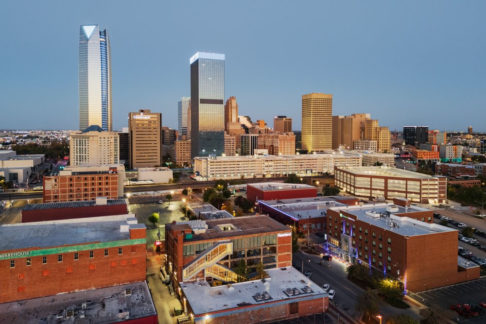 Oklahoma City skyline at Dawn with modern high-rise buildings, city lights, reflections, and visible streets and parking lots, Americana, Historic, USA.