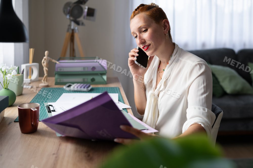 A white woman working from home talks on phone