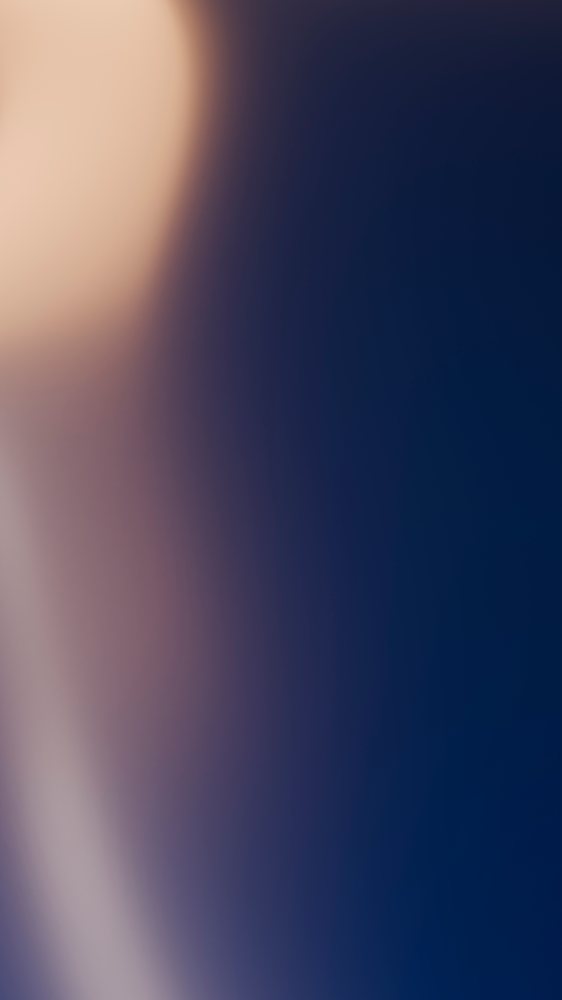 Abstract background featuring a smooth blurred gradient blending beige, purple, and blue tones with soft lighting and texture.