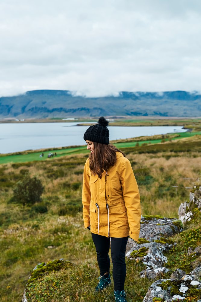 A white woman hikes along rocky terrain