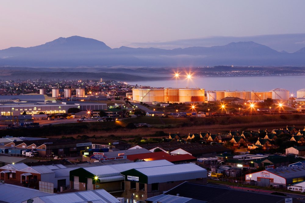 Mossel Bay skyline with industrial storage tanks and mountain range, Dusk, Western Cape, South Africa.
