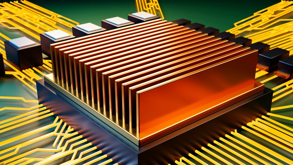Close-up of a computer chip with a golden heat sink mounted atop.
