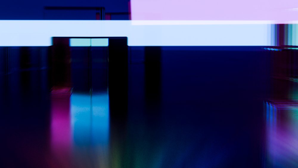 Abstract digital glitch art showing colorful distorted rectangles and lines with blue and purple hues and gradient lighting.