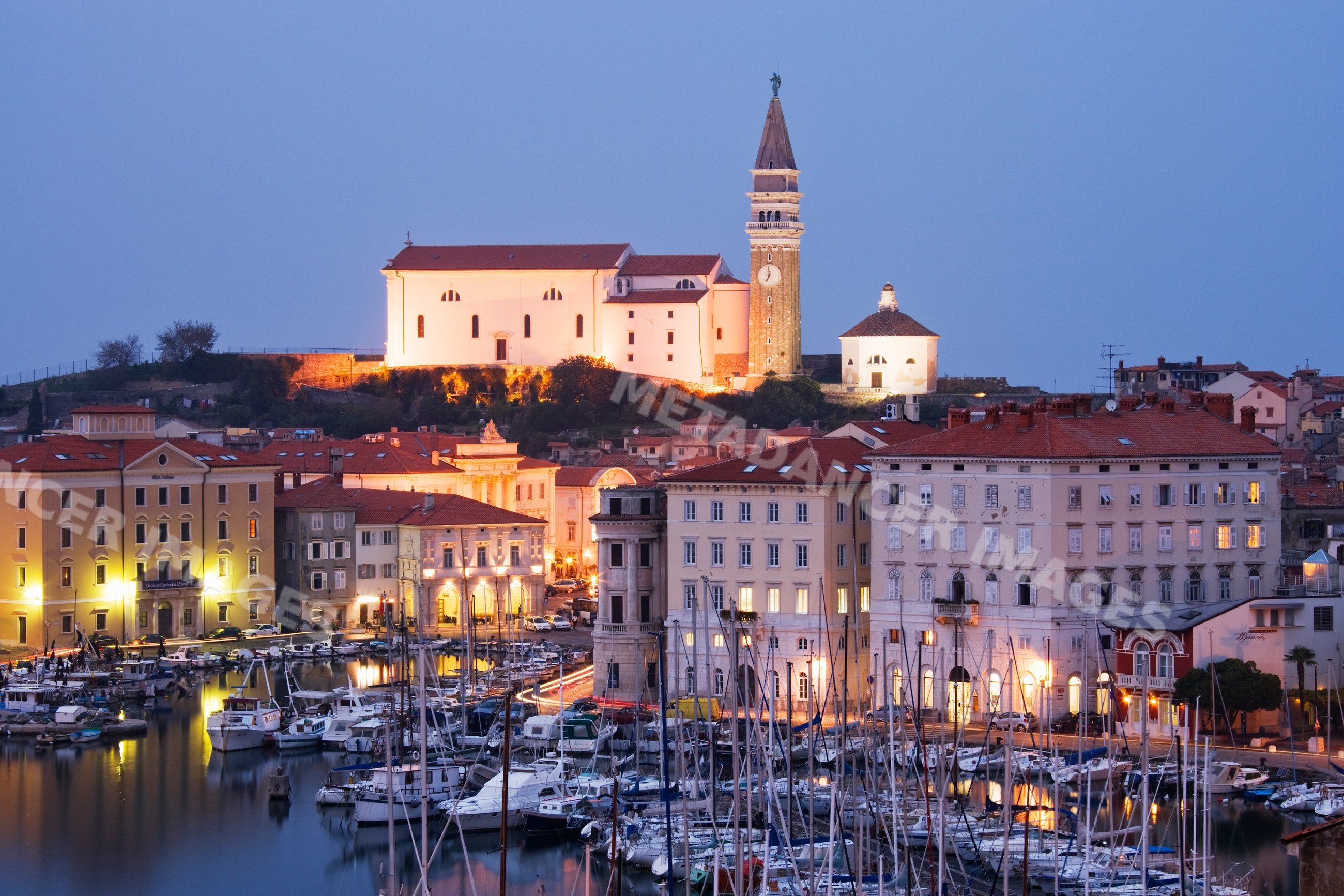 Town of piran harbor with illuminated buildings
