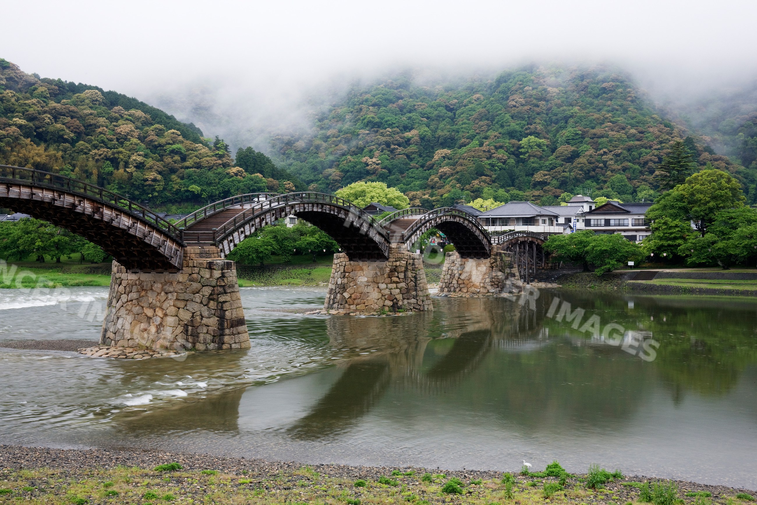 Kintai bridge spanning a foggy river with mountains, japan