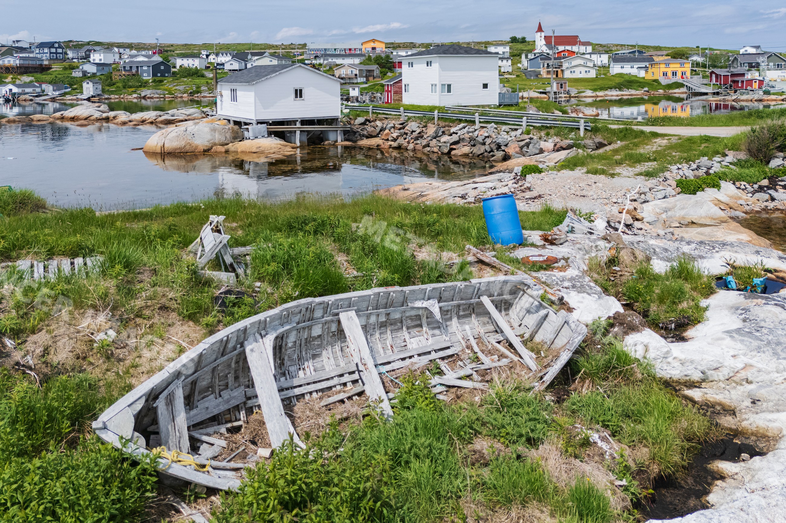 Abandoned wooden boat resting on rocky shore in greenspond harbor