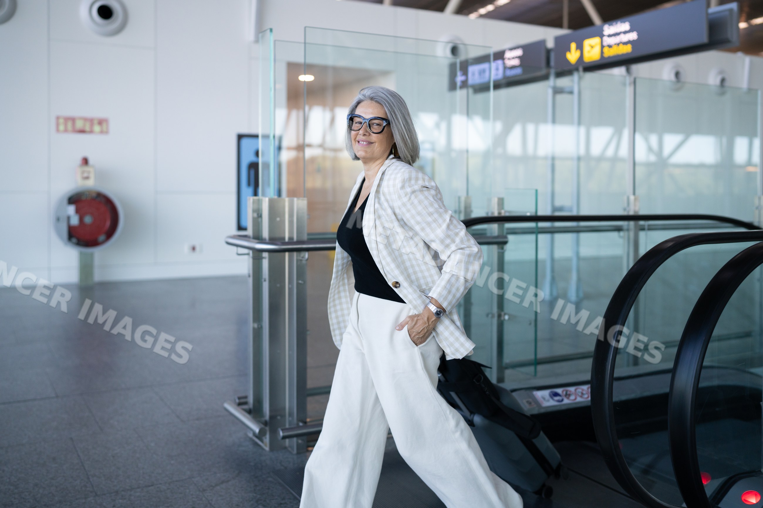 Businesswoman walking with luggage inside airport terminal in Spain