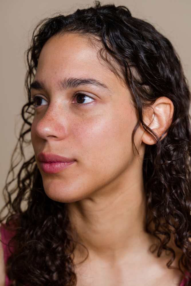 Portrait of Hispanic woman with curly hair looking sideways