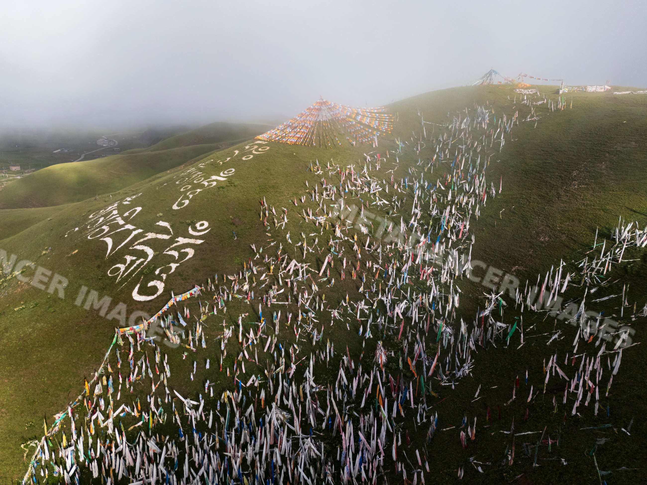 Prayer Flags on a grassy hill in misty Kham Tibet morning