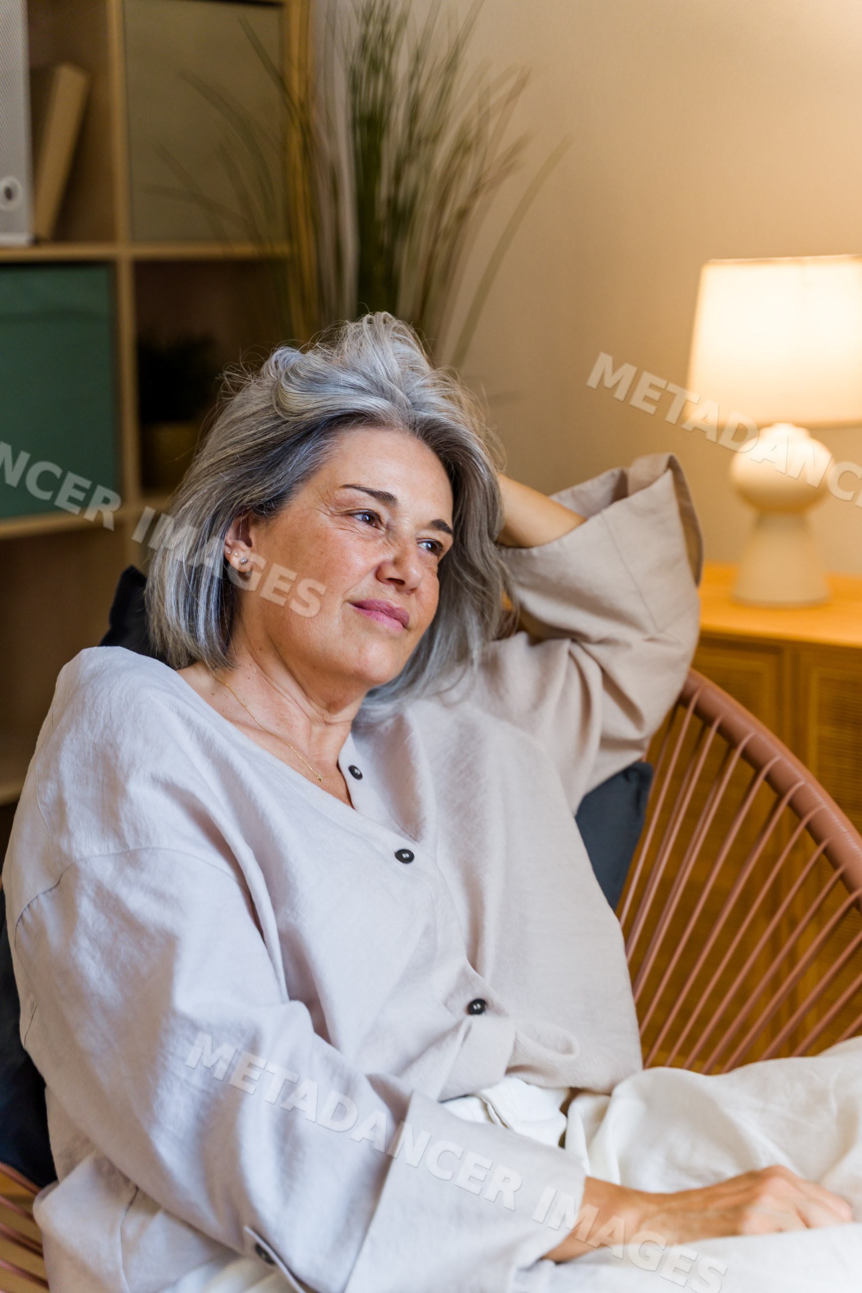Mature white woman relaxing in armchair in contemporary indoor setting
