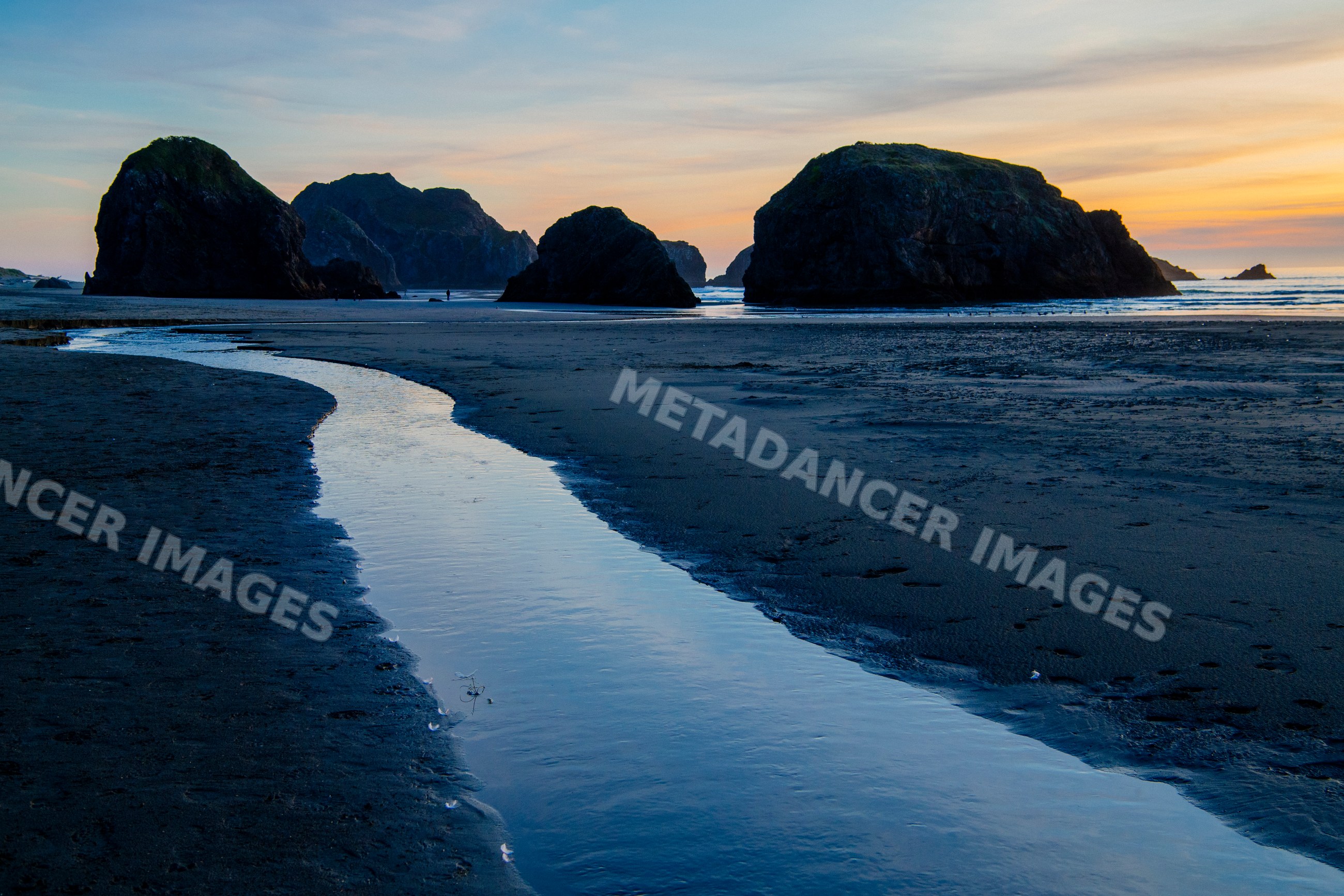 Water channel flowing toward sea stacks at meyers creek beach sunset