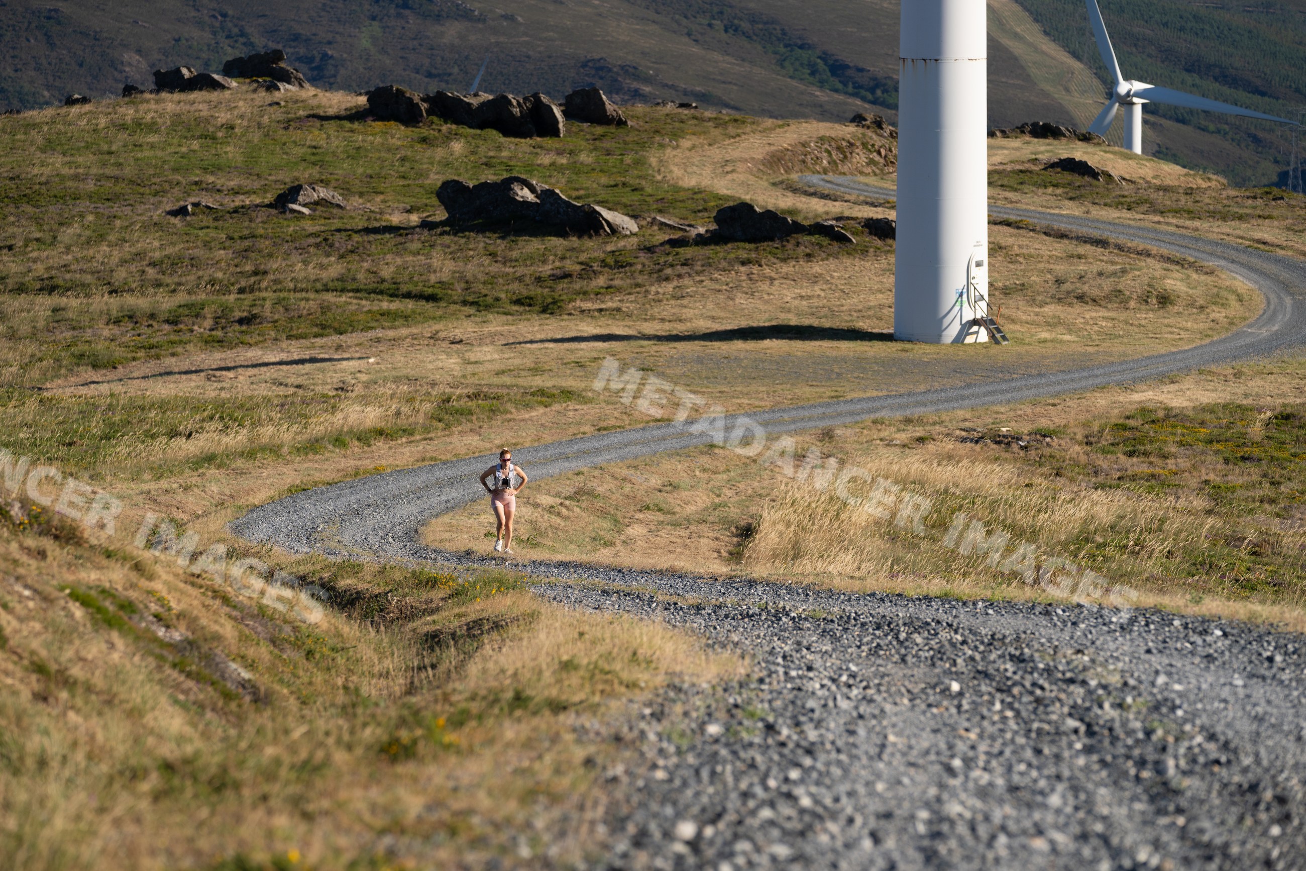 A white woman running on a gravel road