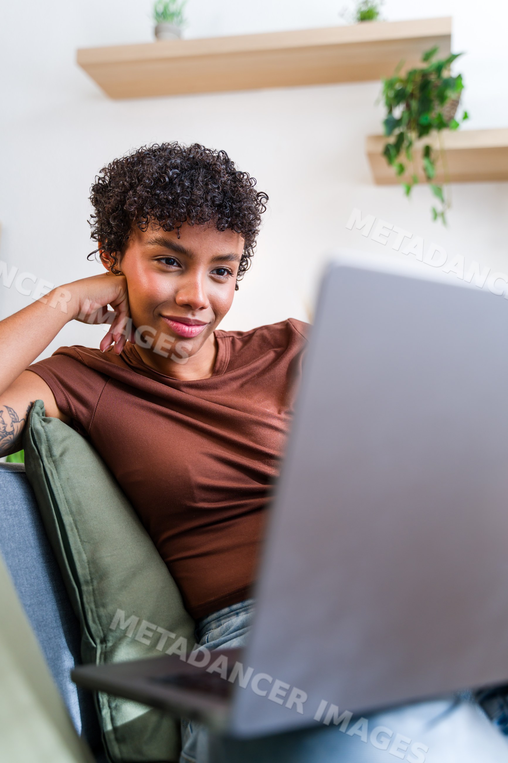 African American woman using laptop on couch