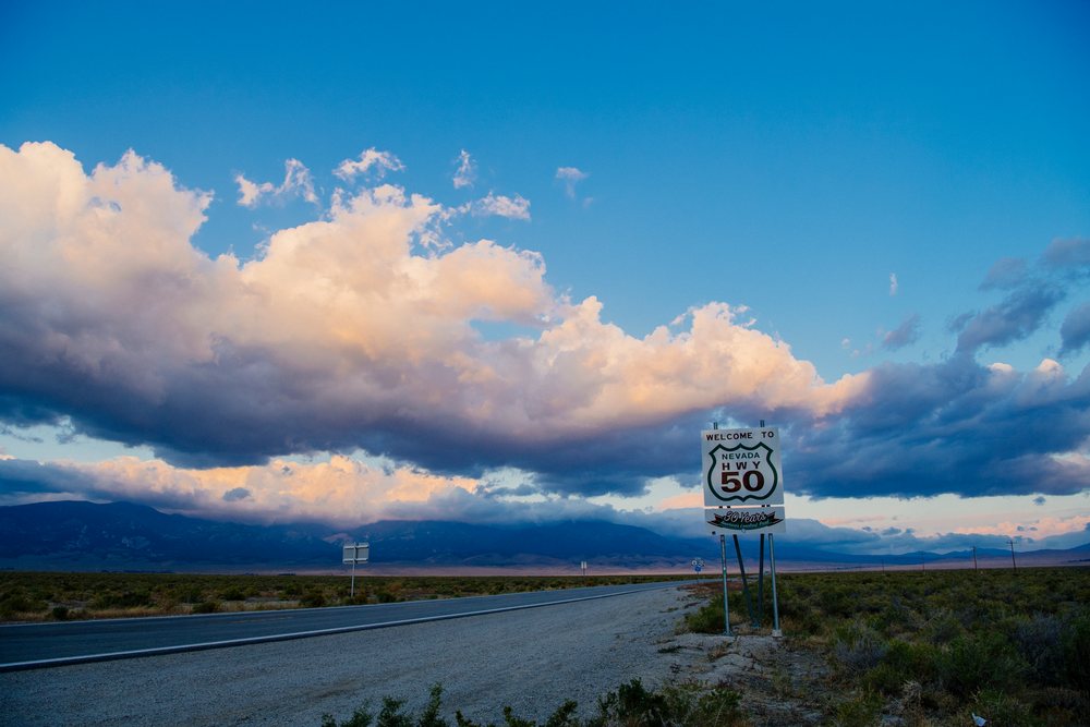 Nevada highway 50 welcome sign on desert roadside at twilight