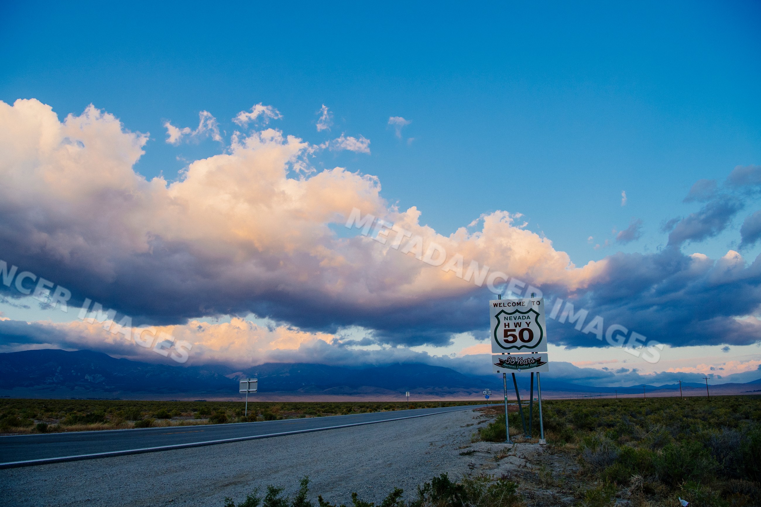 Nevada highway 50 welcome sign on desert roadside at twilight