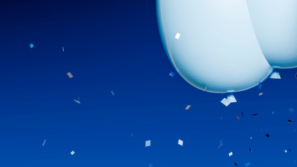 Blue balloon floating with scattered confetti in clear deep blue sky