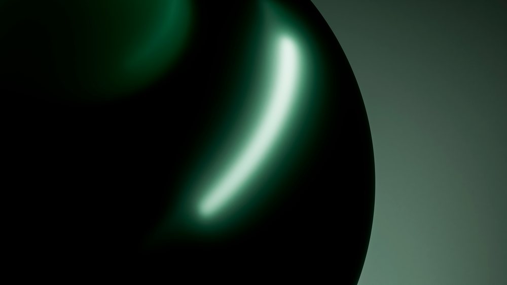 Abstract dark glossy sphere with green lighting and reflections