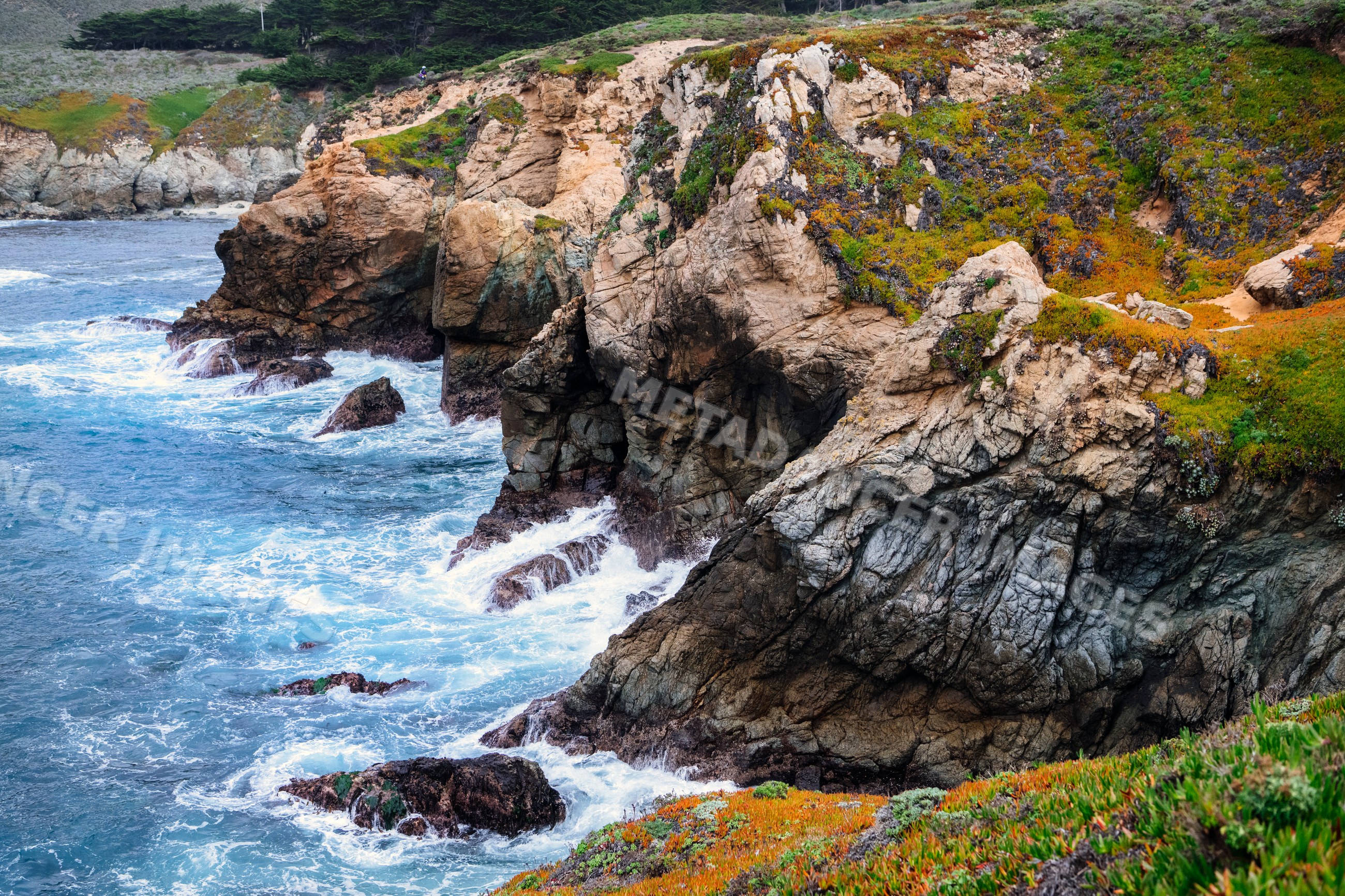 Rocky coastline with waves crashing against California cliffs