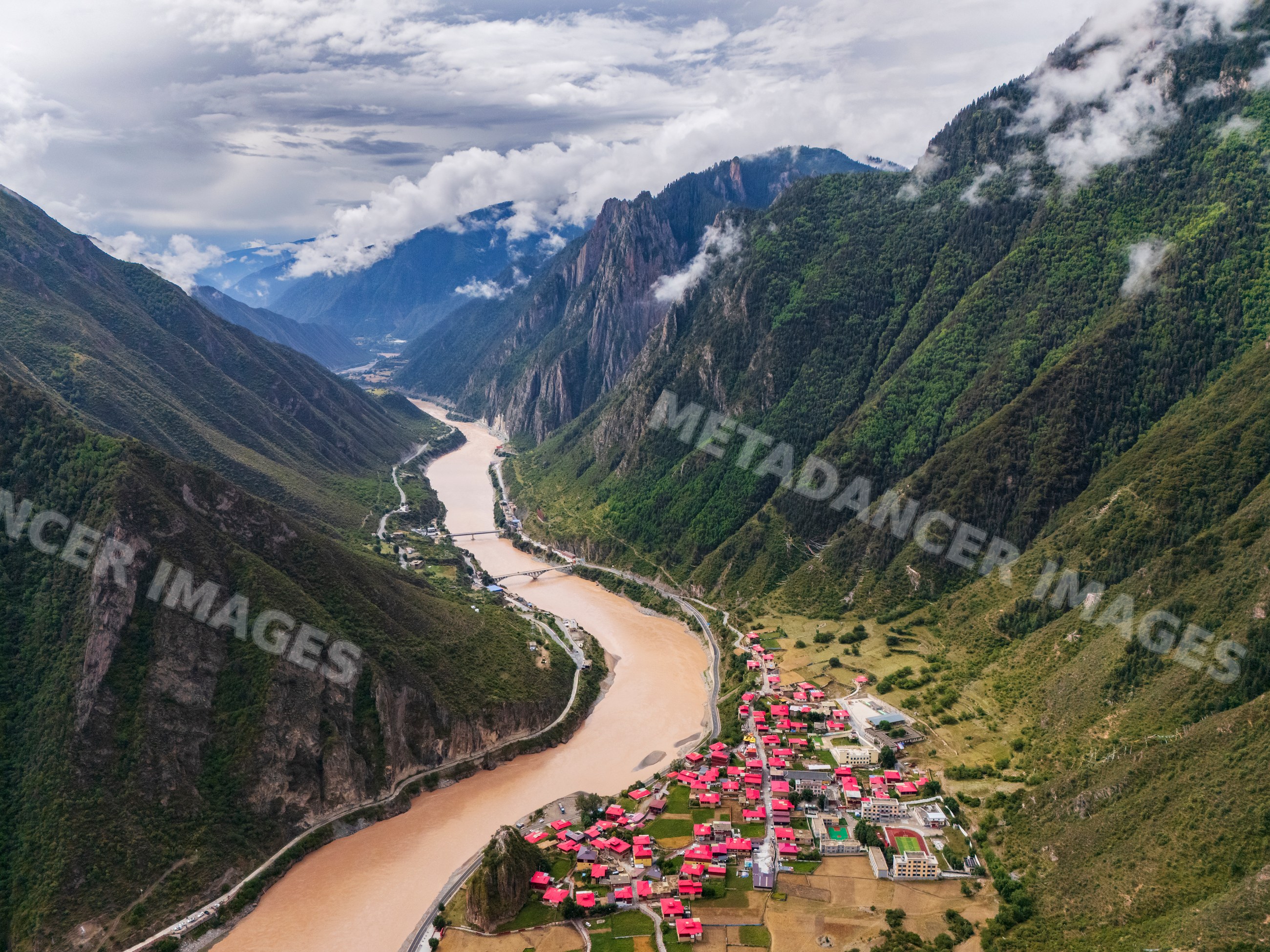 Jinsha river and red roof village in mountain valley sichuan province