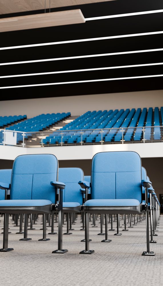 Rows of blue chairs in a spacious modern auditorium