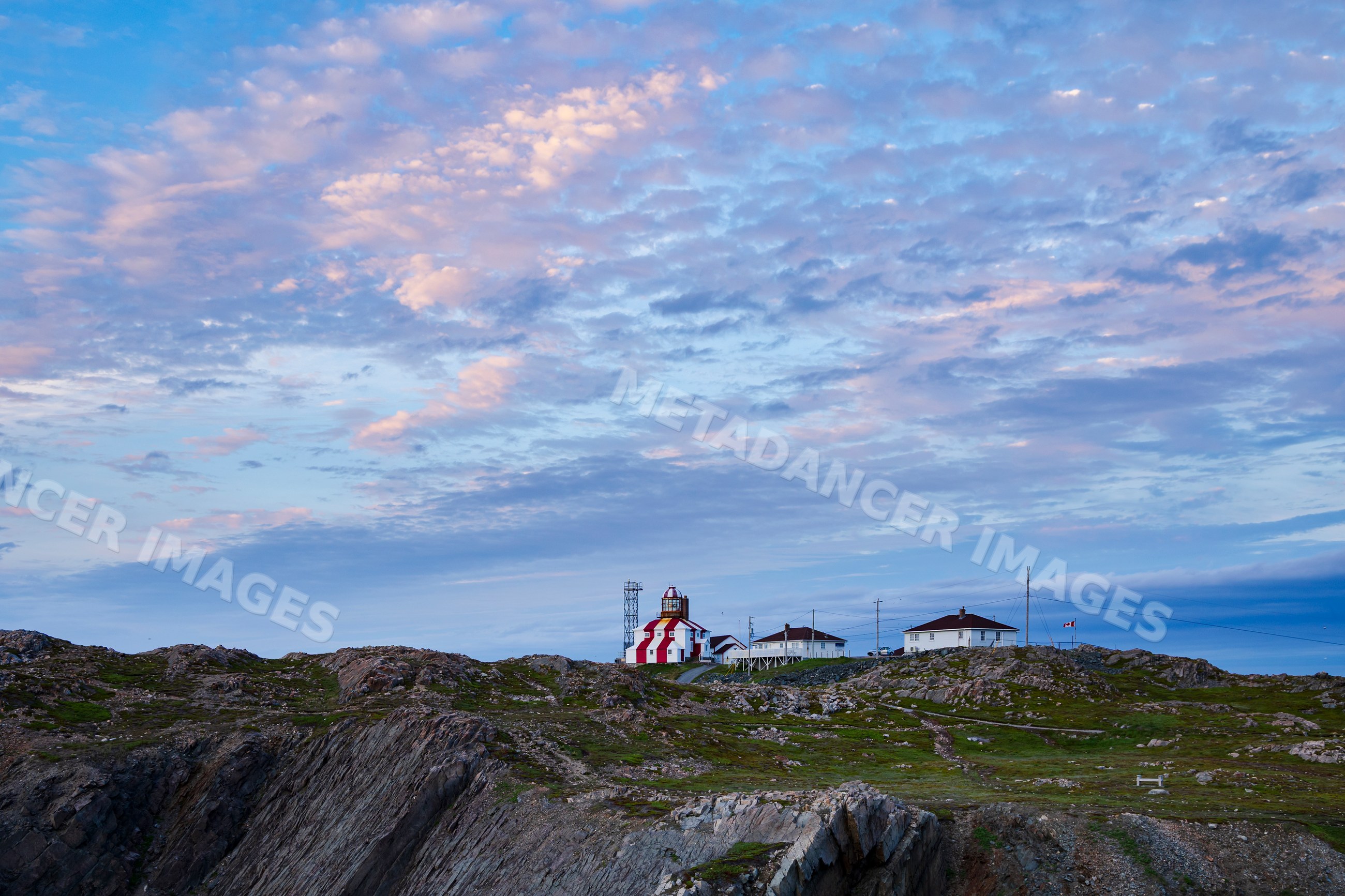 Cape Bonavista lighthouse at Sunset on rocky hill in Bonavista
