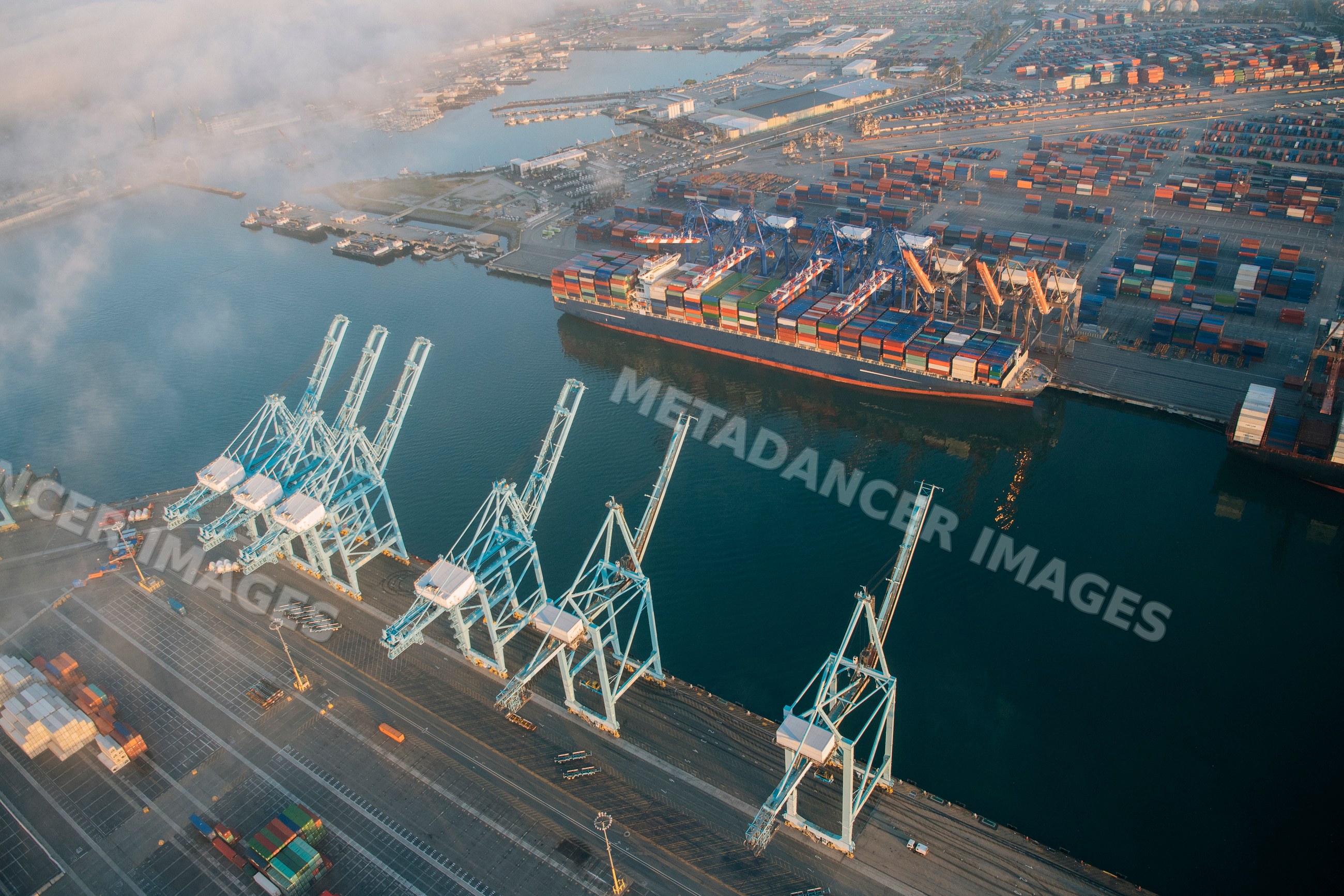 Container ship docked at port with cargo containers and cranes