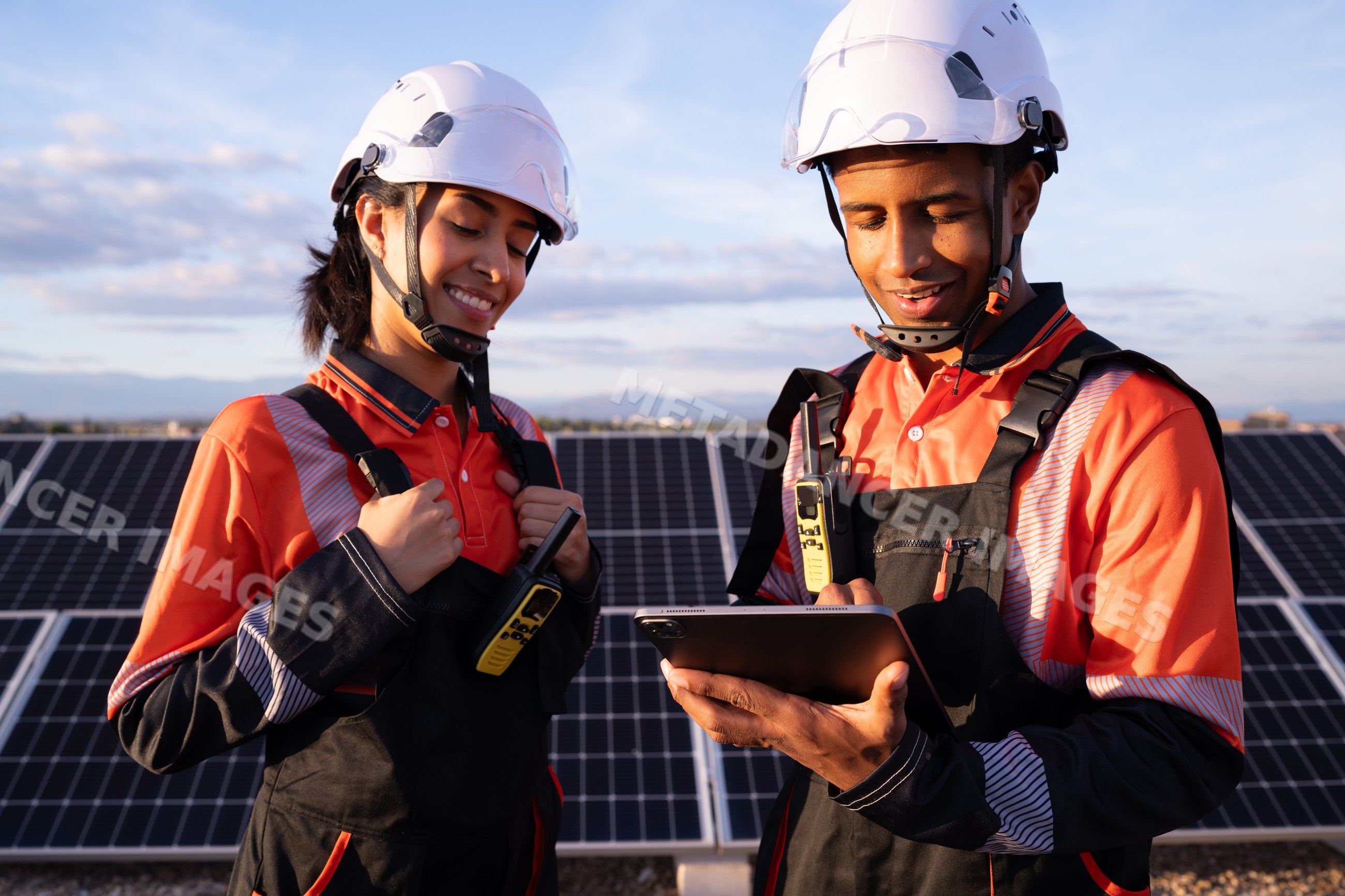 Technicians inspecting solar panel installation outdoors