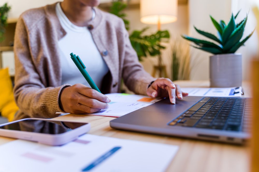 African American person scheduling and working on laptop