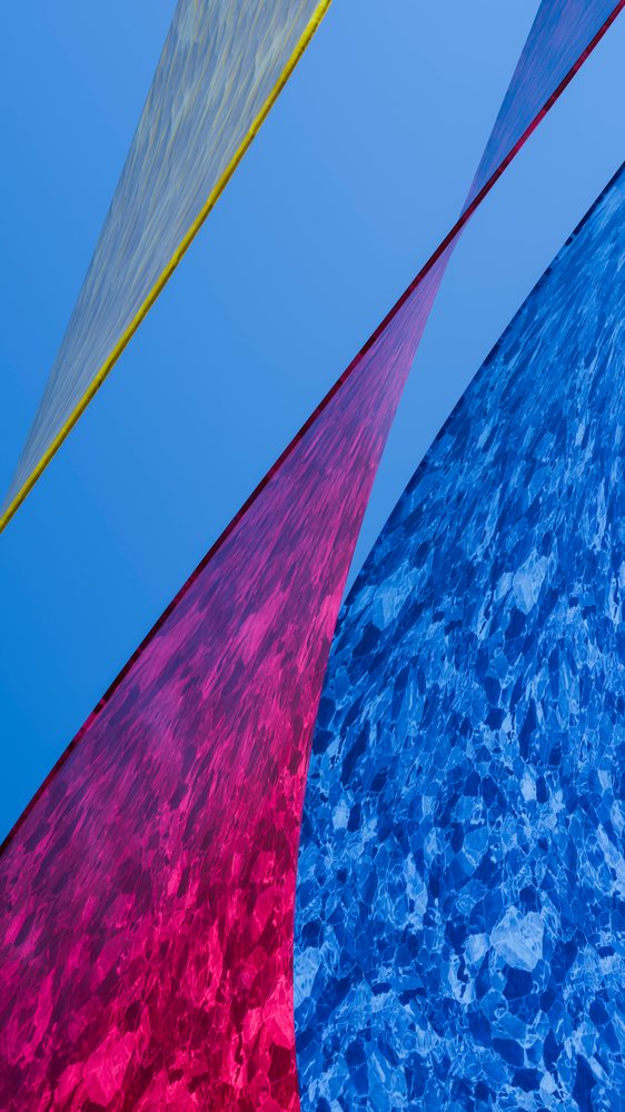 Abstract composition of colored fabric panels against blue sky