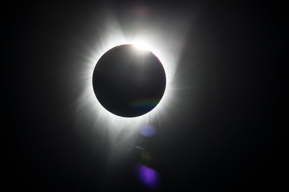 Solar eclipse displaying moon silhouette and sun corona over Los