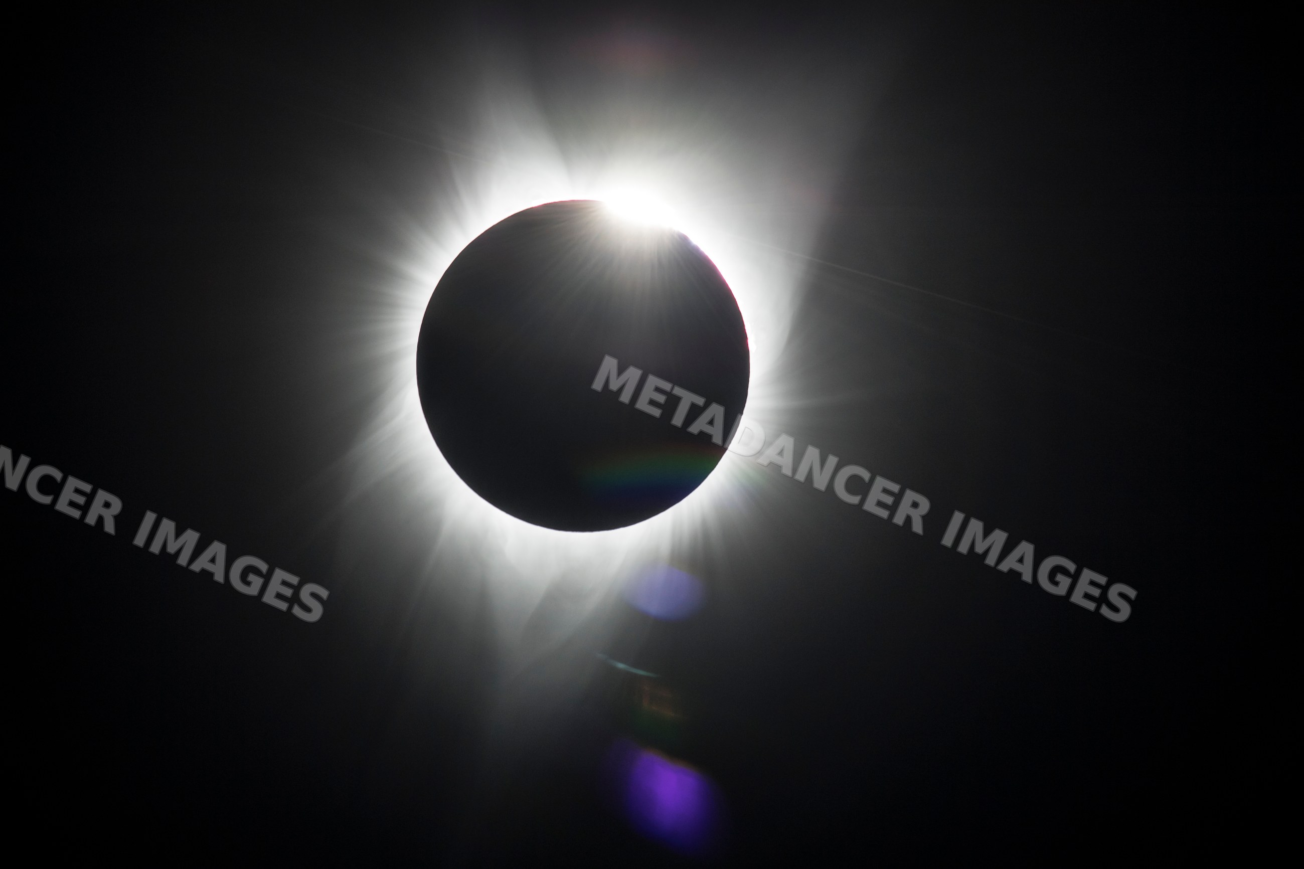 Solar eclipse displaying moon silhouette and sun corona over Los