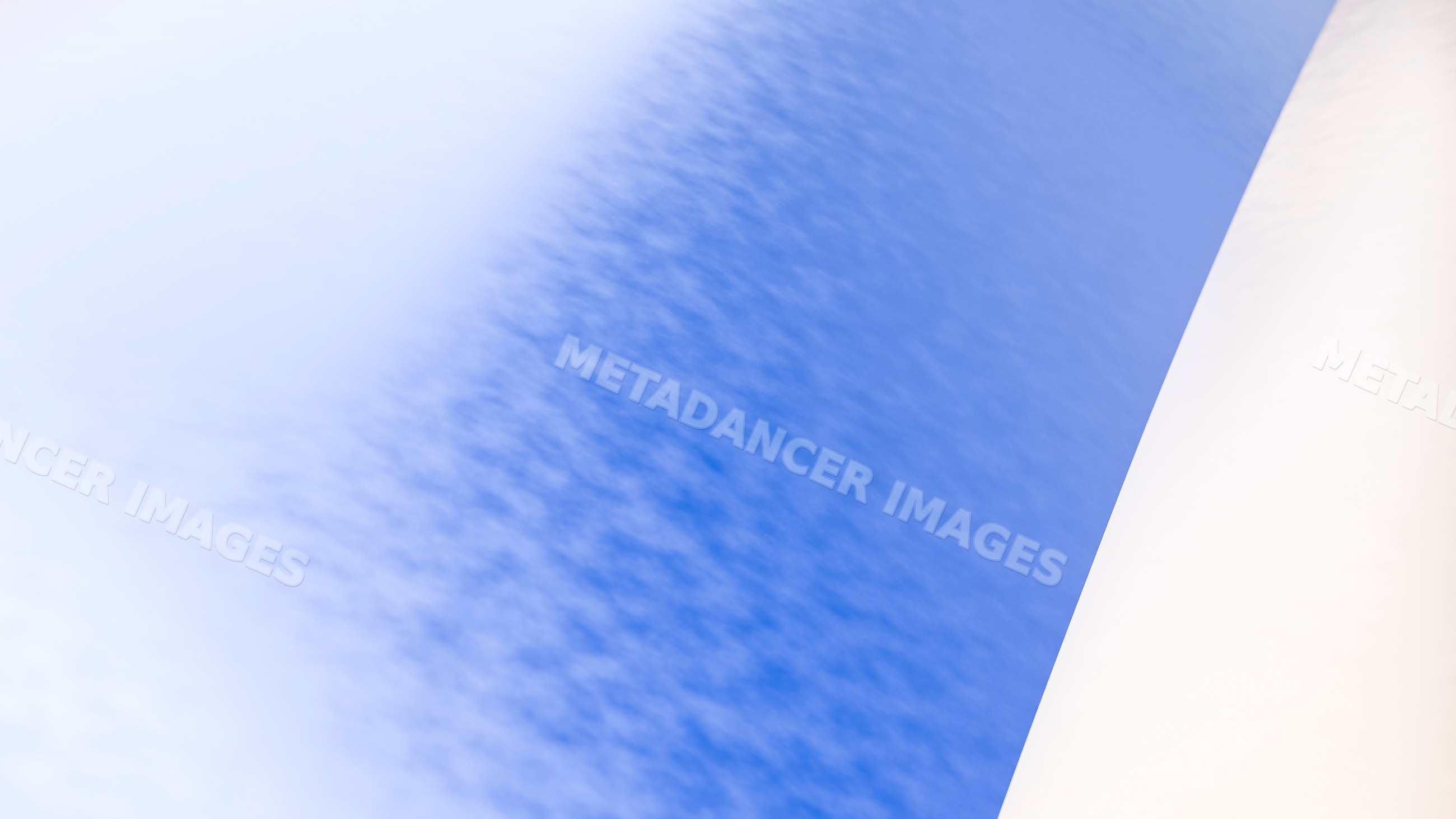 White pillar under blue sky with scattered clouds outdoors