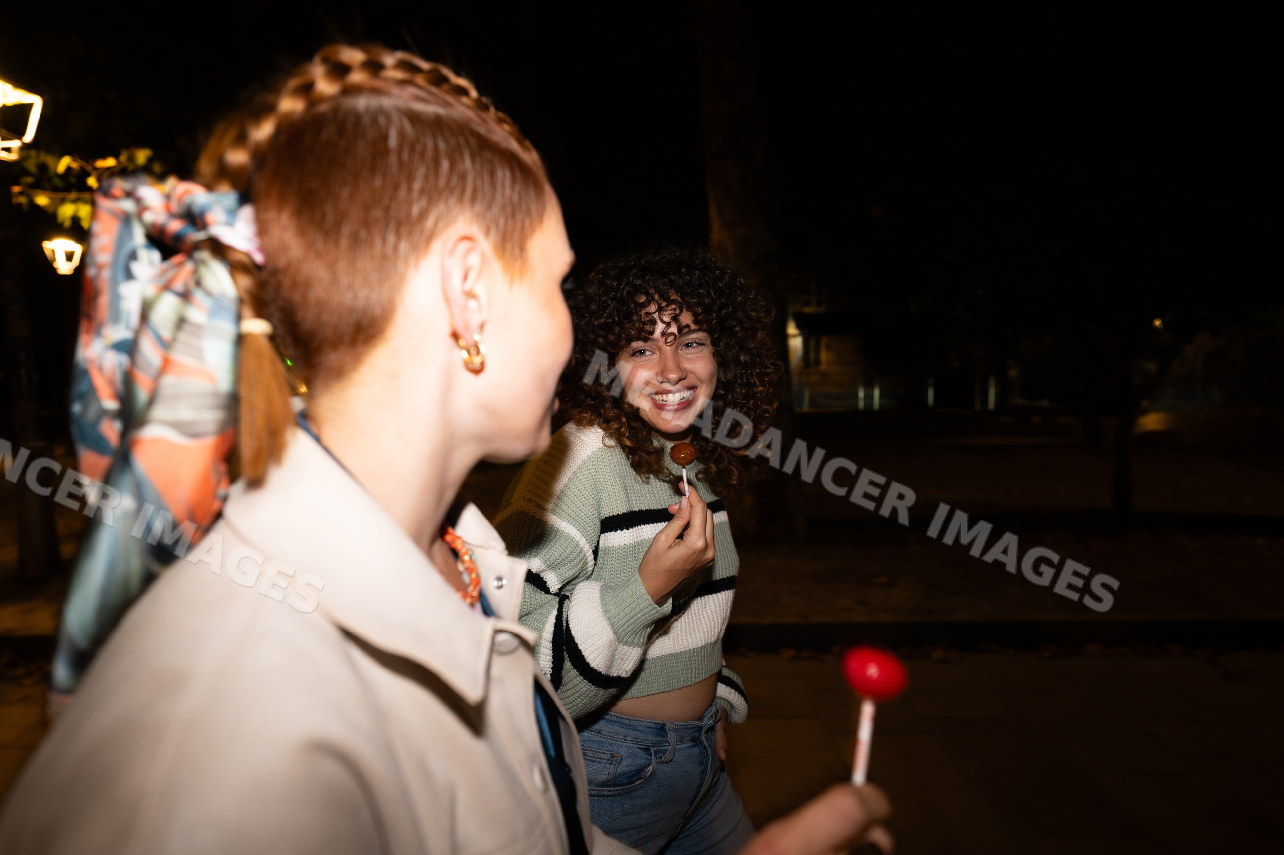 Friends walking at night with lollipops