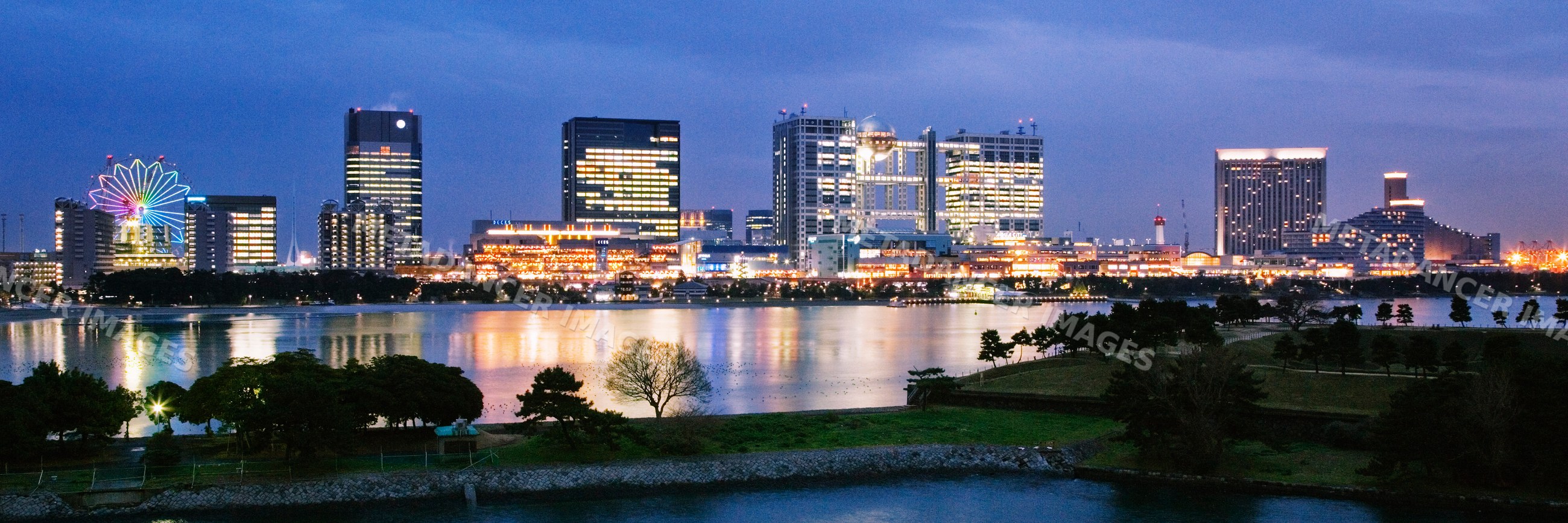 Aqua city and fuji tv building illuminated at night