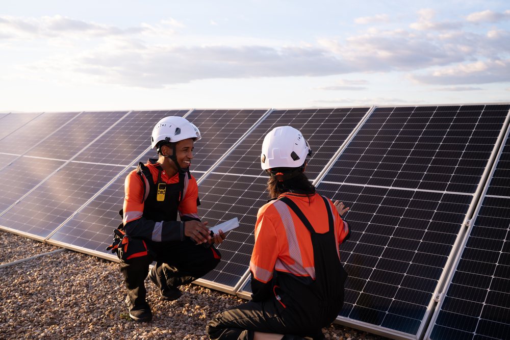 Hispanic workers inspecting solar panels outdoors in Madrid, Spain