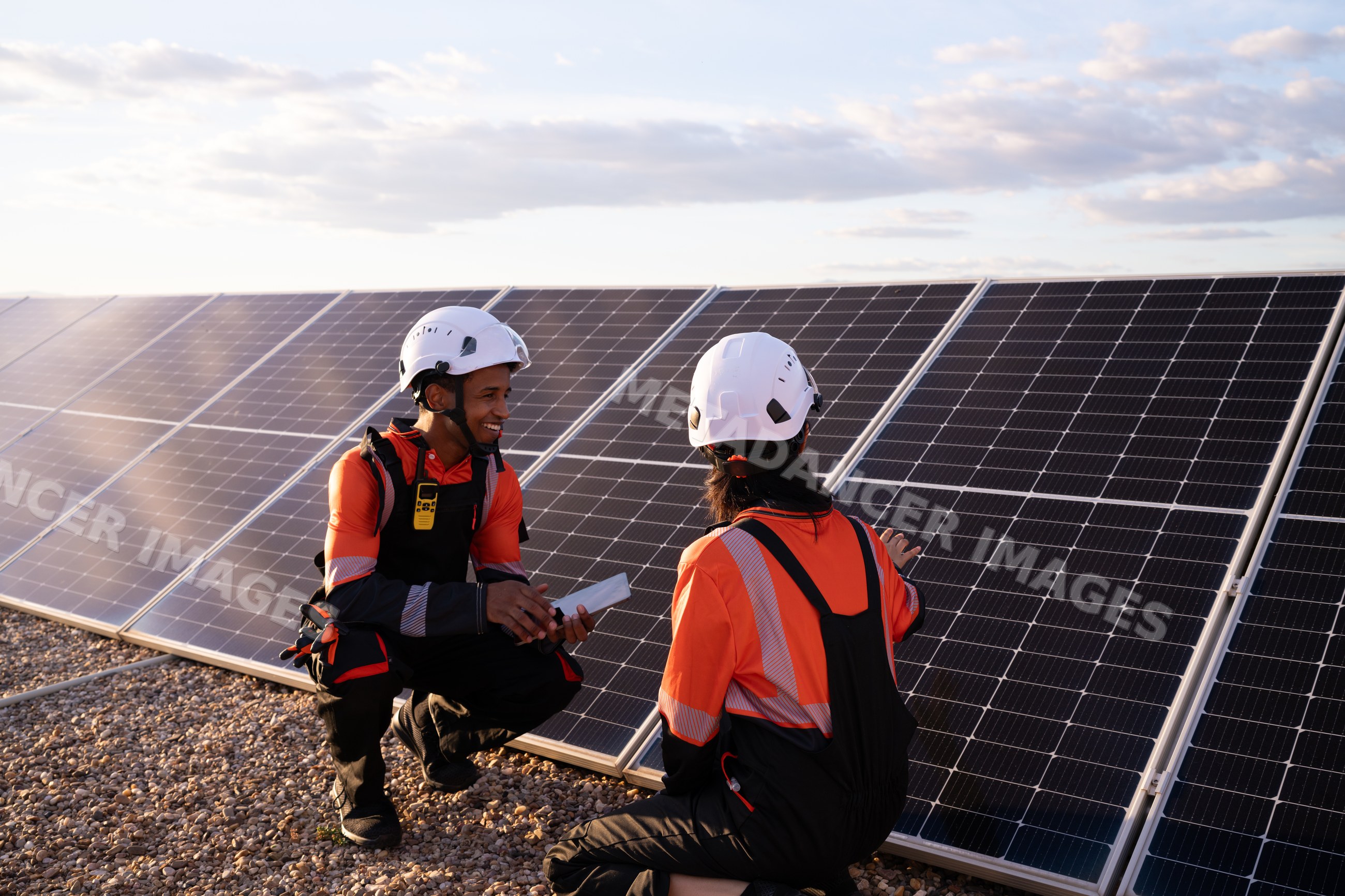 Hispanic workers inspecting solar panels outdoors in Madrid, Spain