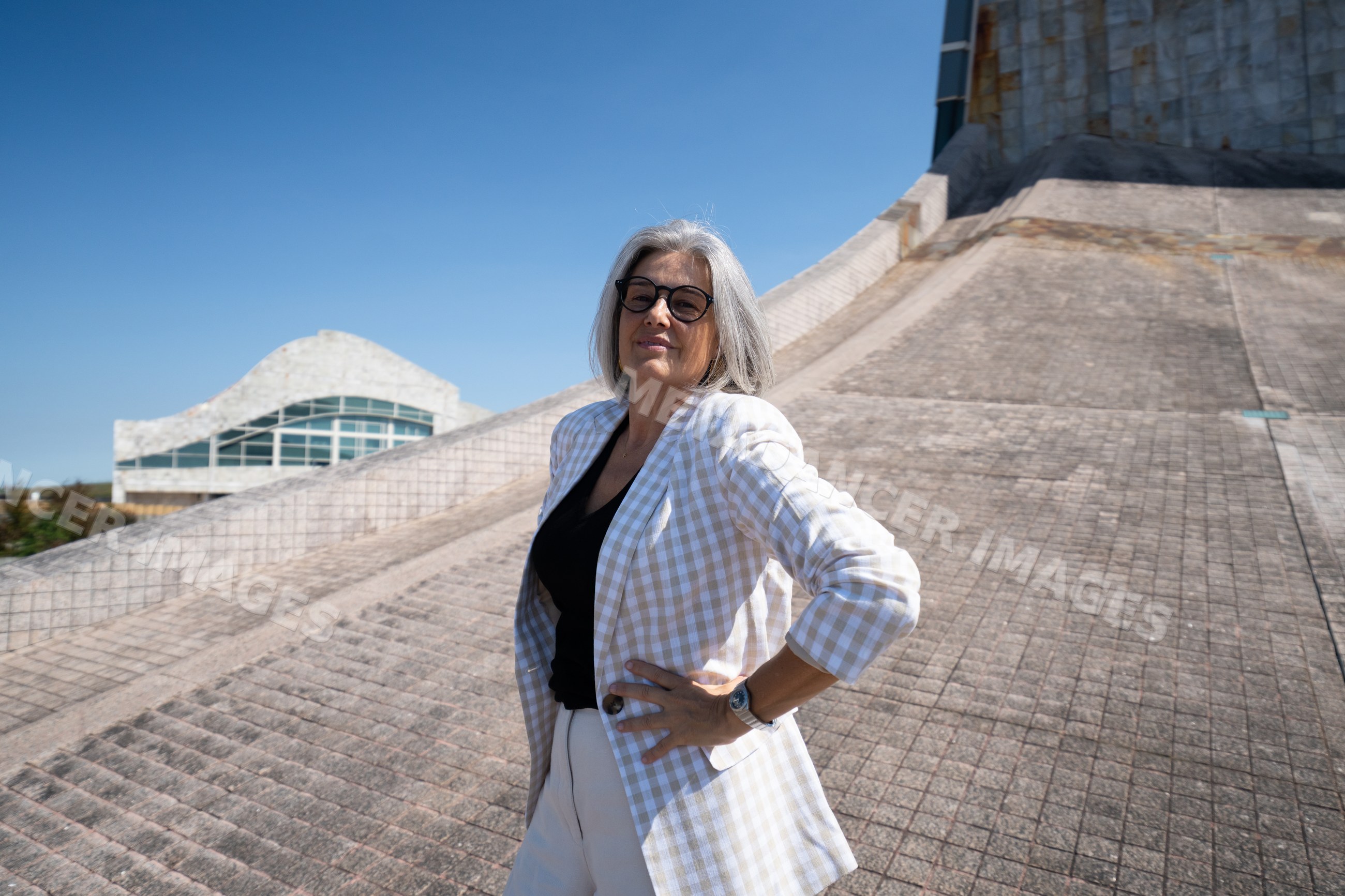 Businesswoman with gray hair wearing plaid blazer outdoors