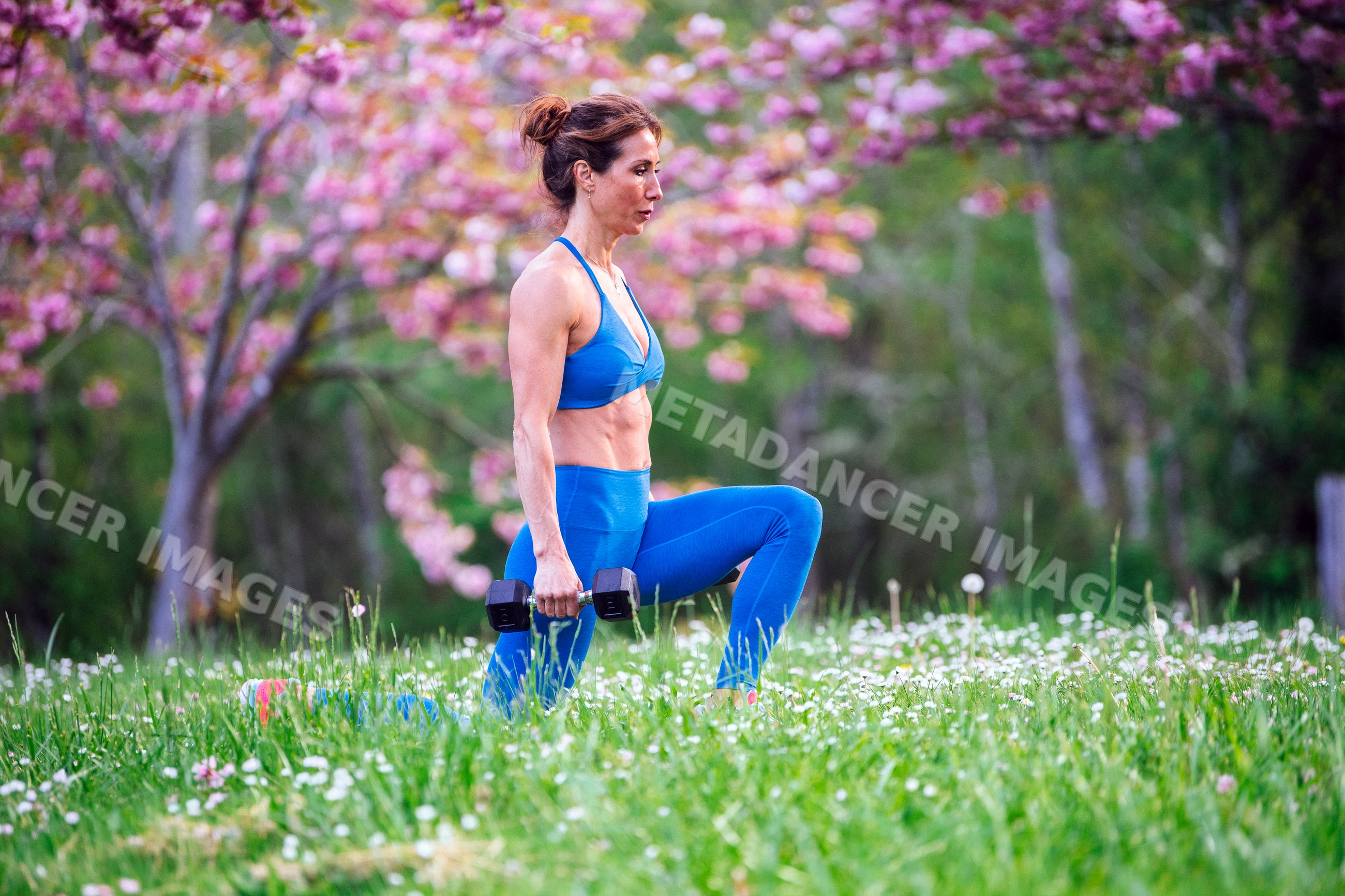 White woman exercising with dumbbells outdoors