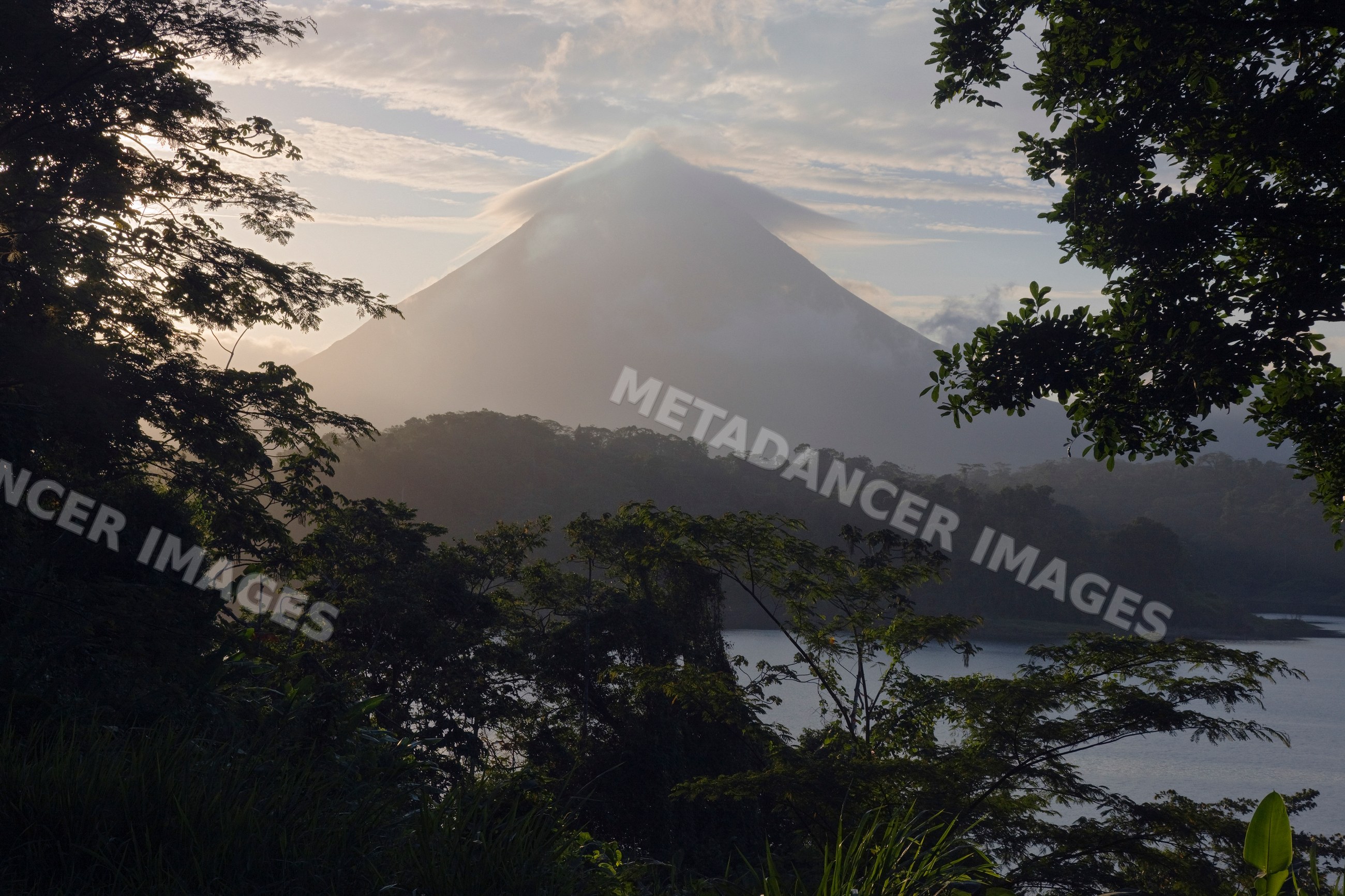 Arenal volcano at dawn with mist and lake, costa rica