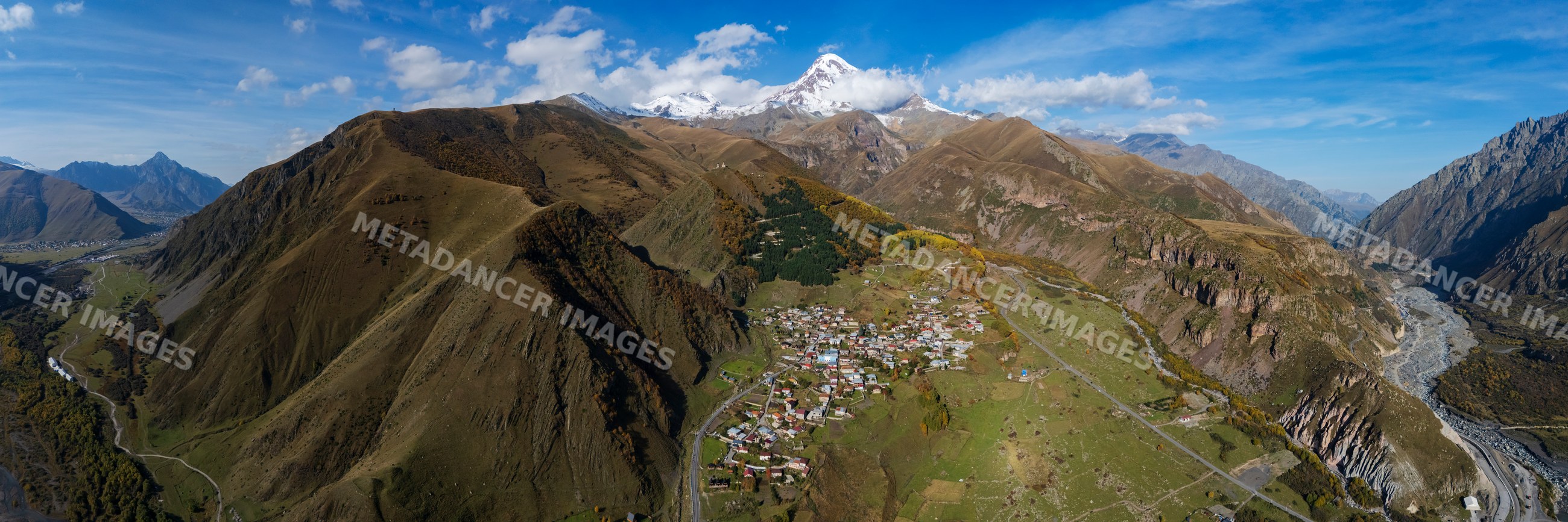 View of Kazbegi Peak and village of Gergeti in Georgia mountains