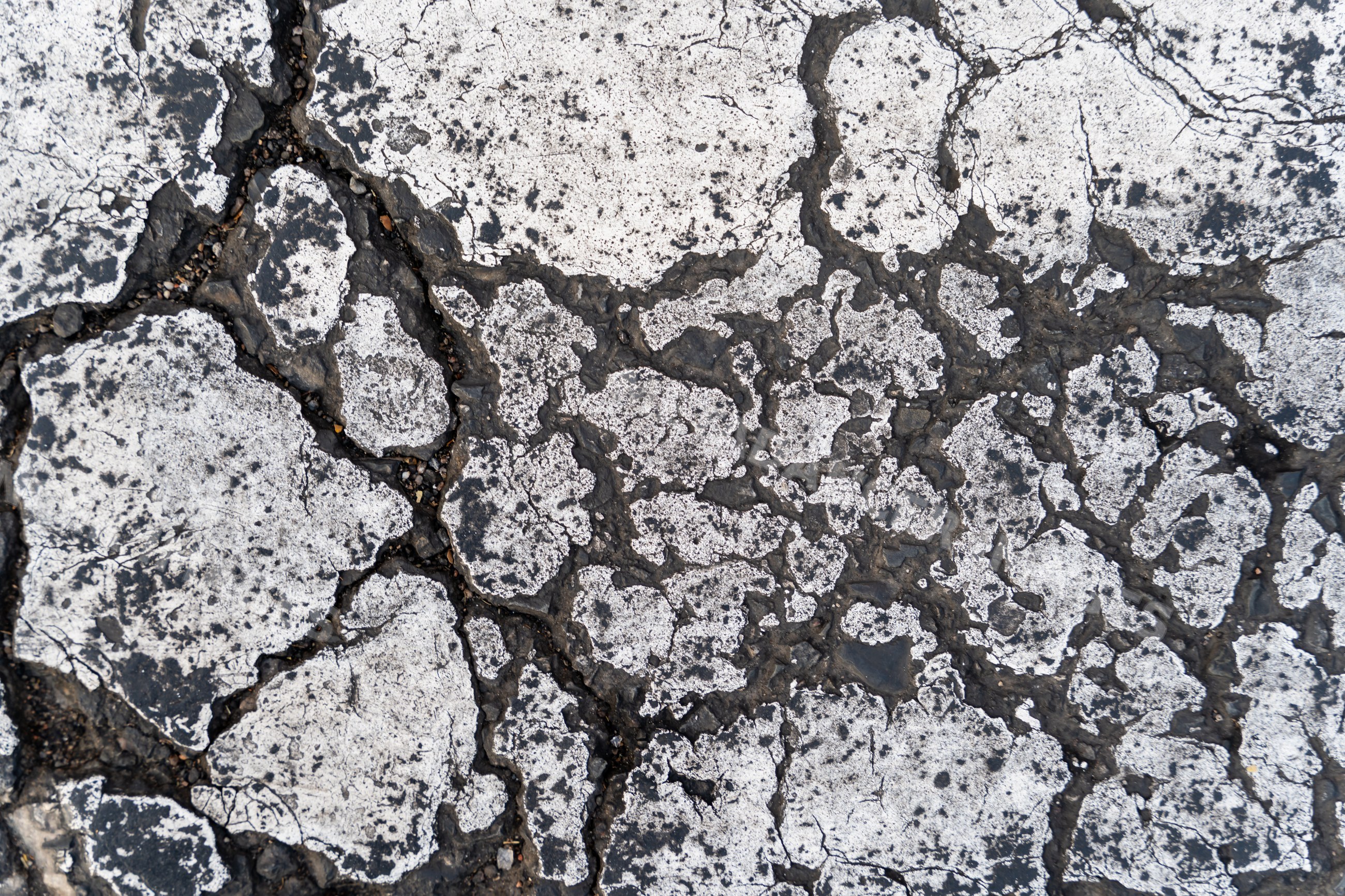 Cracked asphalt pavement with weathered surface texture outdoors