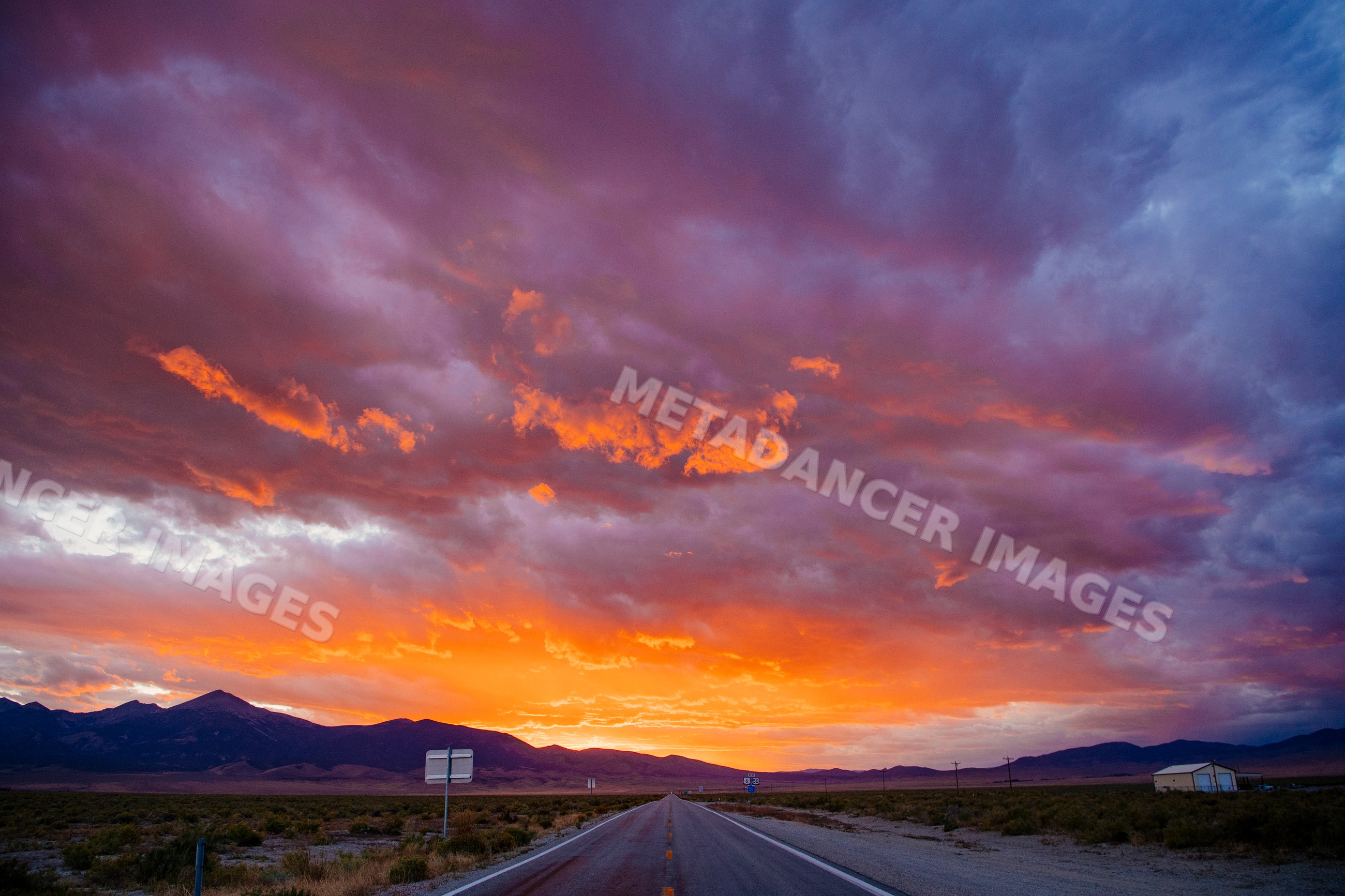Sunset sky over open road and mountains in Nevada desert