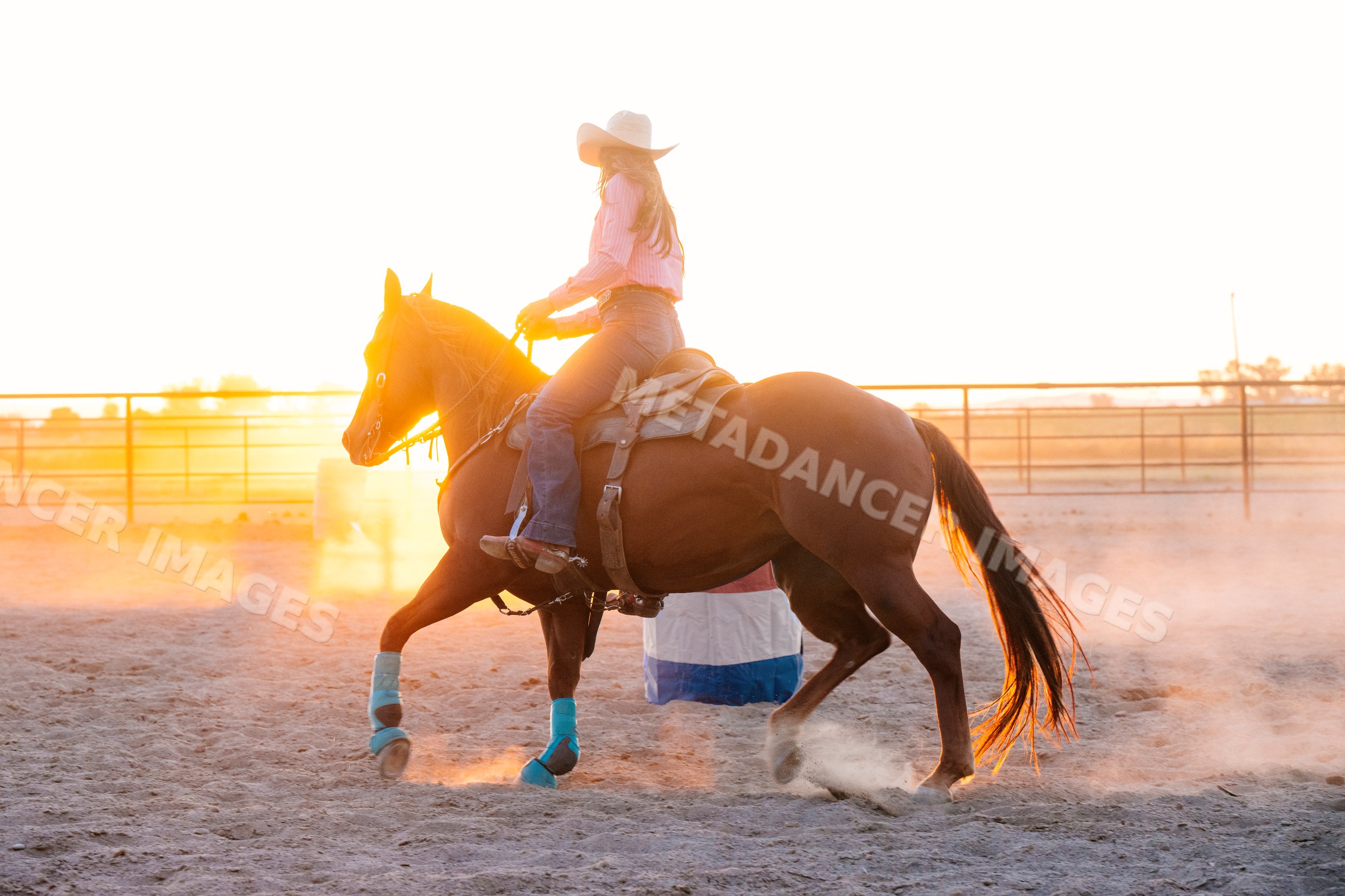 Horseback rider in a dusty arena at sunset in Southwest USA
