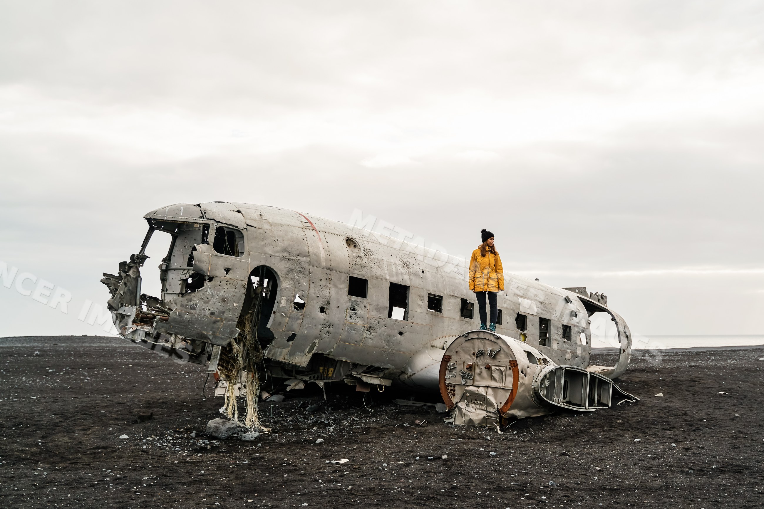 A white woman explores the wrecked airplane fuselage