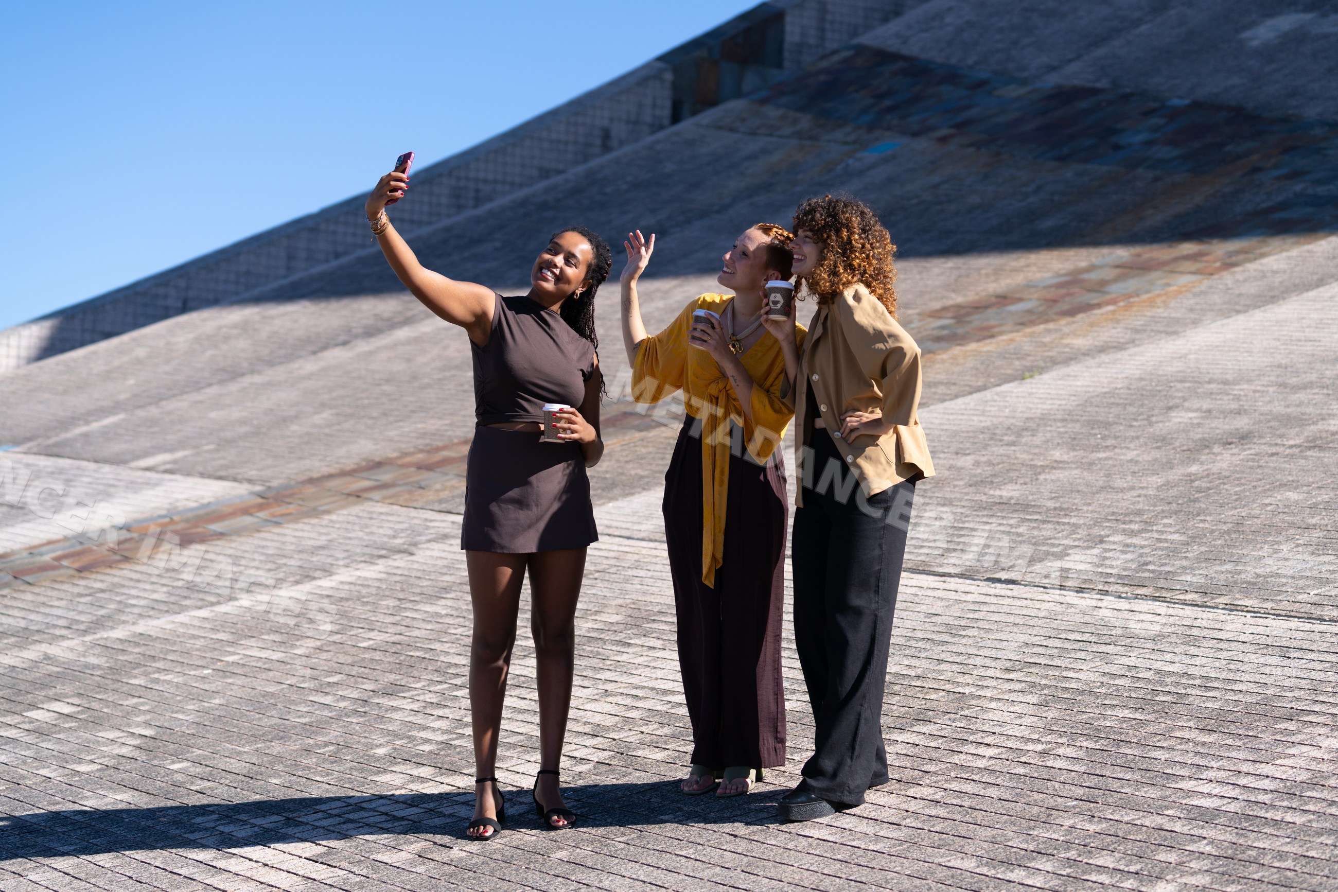 Three African American and white women taking selfie outdoors